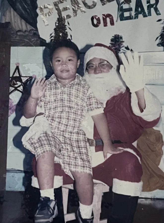 Ian as a boy on Santa&rsquo;s lap, waving
